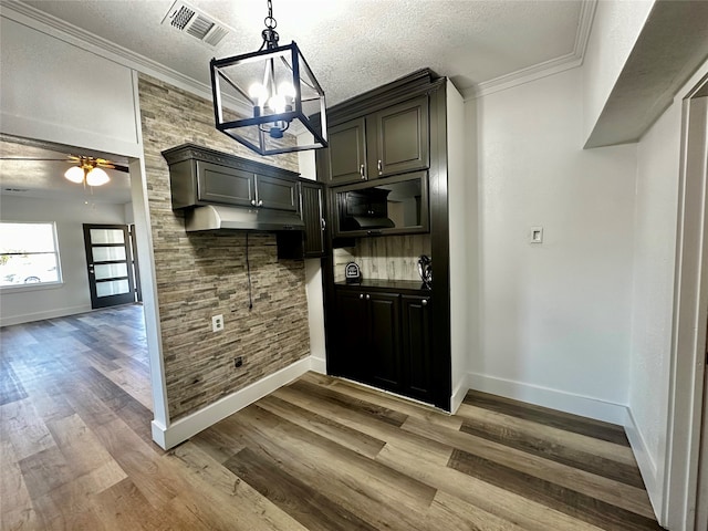 kitchen with light hardwood / wood-style flooring, ceiling fan with notable chandelier, a textured ceiling, and ornamental molding