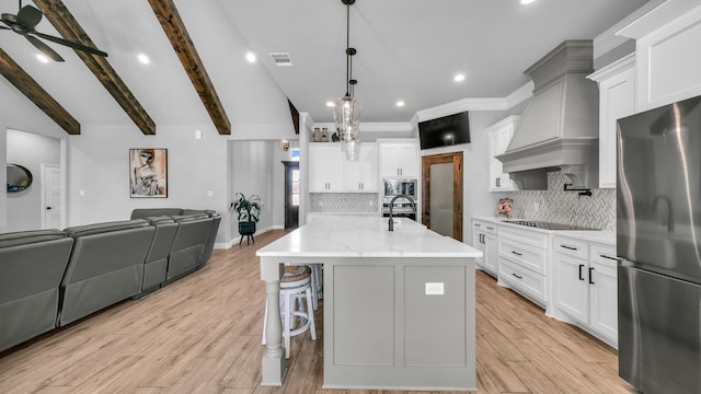 kitchen with pendant lighting, a large island, white cabinets, and appliances with stainless steel finishes