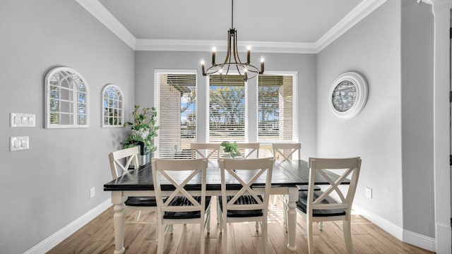 dining area with an inviting chandelier, crown molding, and light hardwood / wood-style flooring