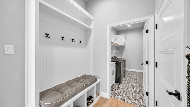 mudroom with light wood-type flooring and independent washer and dryer