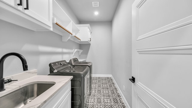 washroom featuring tile patterned flooring, cabinets, independent washer and dryer, and sink