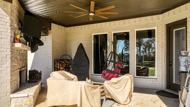 view of patio featuring an outdoor stone fireplace and ceiling fan