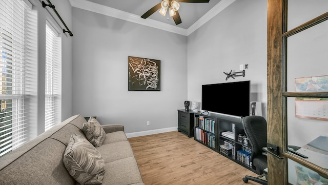 living room with light hardwood / wood-style flooring, a wealth of natural light, crown molding, and ceiling fan