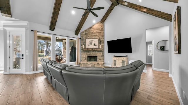 living room with beamed ceiling, a fireplace, high vaulted ceiling, and light hardwood / wood-style flooring