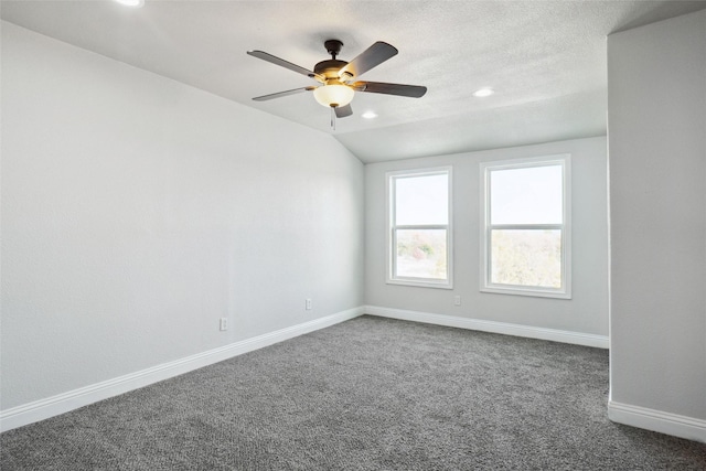 carpeted empty room with vaulted ceiling and ceiling fan