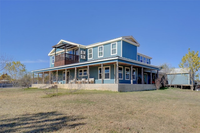 back of house featuring a balcony and a lawn