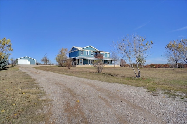 view of front of home with an outbuilding, a garage, covered porch, and a front yard