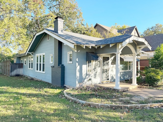 rear view of house featuring a yard