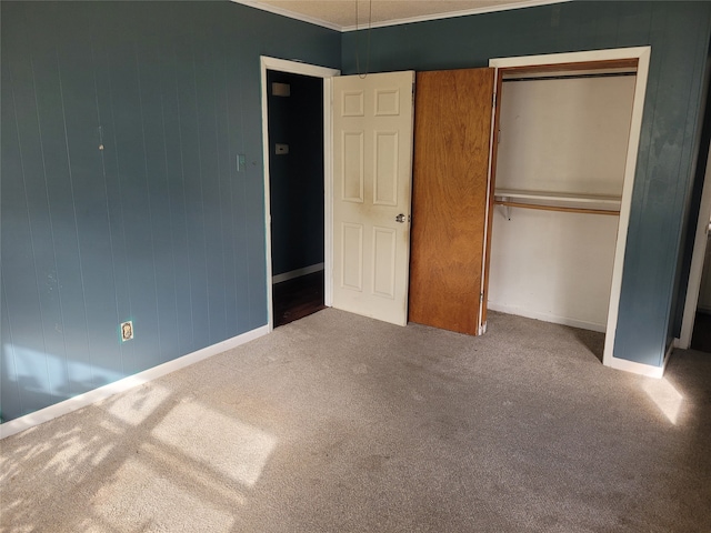 unfurnished bedroom featuring carpet, a closet, and crown molding