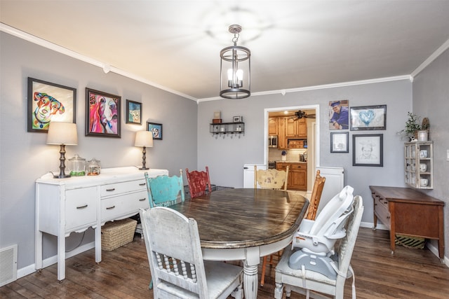 dining space featuring a chandelier, crown molding, and dark wood-type flooring