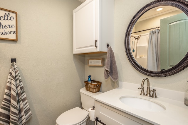 bathroom featuring curtained shower, vanity, and toilet