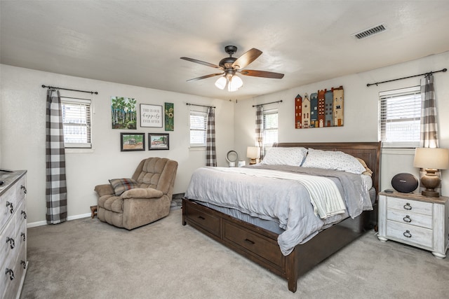 carpeted bedroom with multiple windows and ceiling fan