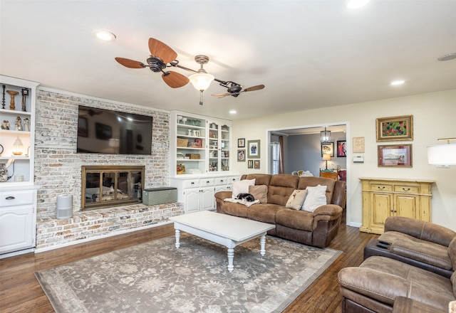 living room featuring a fireplace, dark hardwood / wood-style flooring, built in features, and ceiling fan