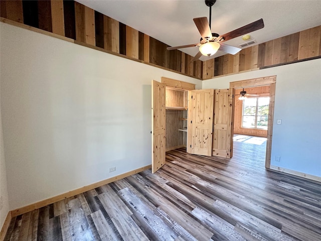 unfurnished room featuring dark wood-type flooring and ceiling fan