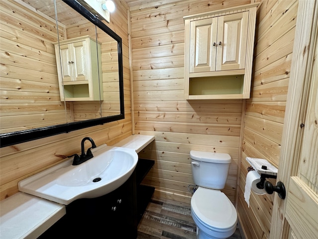 bathroom with vanity, wood walls, toilet, and wood-type flooring