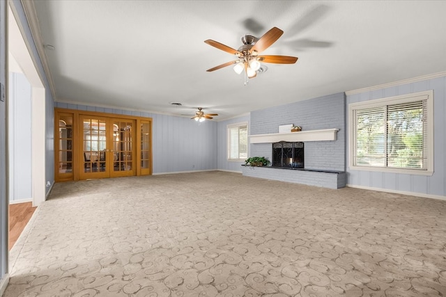 unfurnished living room with french doors, a brick fireplace, ceiling fan, and ornamental molding