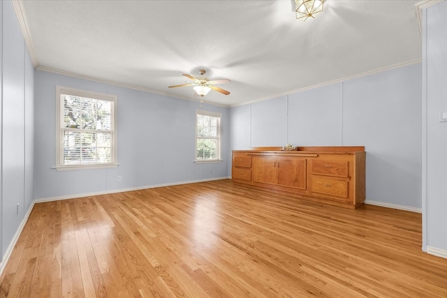 unfurnished room featuring light hardwood / wood-style flooring, a wealth of natural light, ornamental molding, and ceiling fan