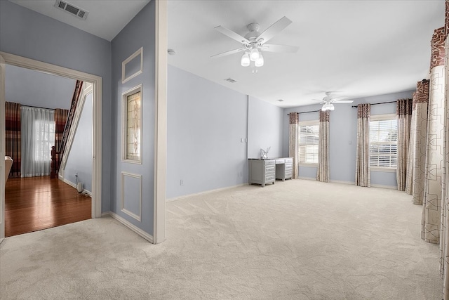 unfurnished living room with light carpet and ceiling fan