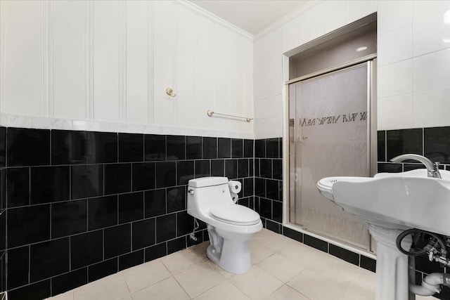 bathroom with tile patterned floors, a shower with shower door, tile walls, and toilet