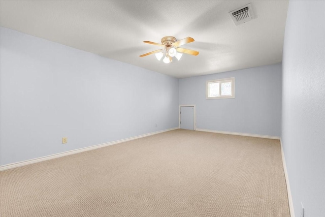 spare room featuring ceiling fan and light carpet