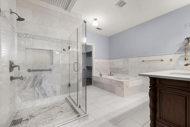 bathroom with tile patterned floors, vanity, tile walls, and plus walk in shower