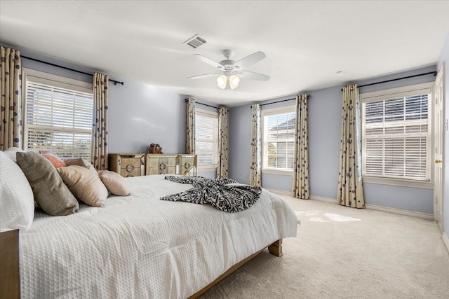 carpeted bedroom featuring multiple windows and ceiling fan