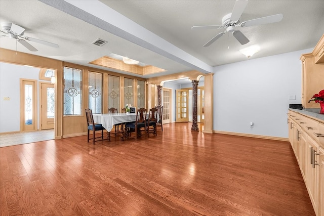 dining area featuring wood-type flooring, a textured ceiling, and ceiling fan