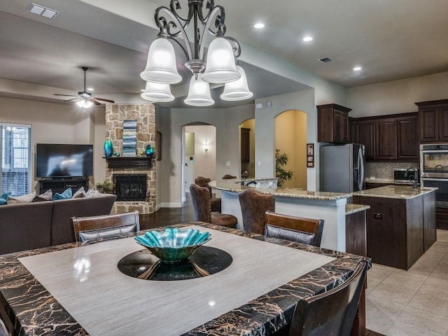 kitchen featuring a center island with sink, visible vents, appliances with stainless steel finishes, open floor plan, and decorative light fixtures