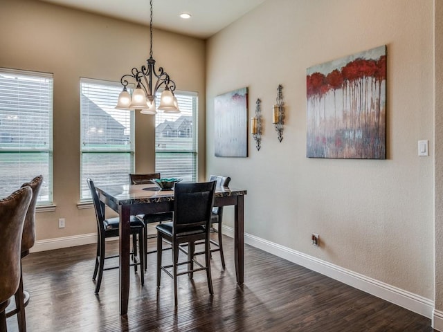 dining space with dark wood-style floors, a chandelier, and baseboards