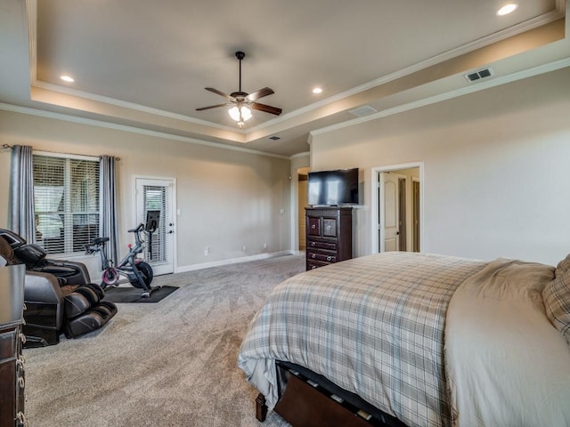 bedroom featuring visible vents, baseboards, ornamental molding, a tray ceiling, and carpet floors