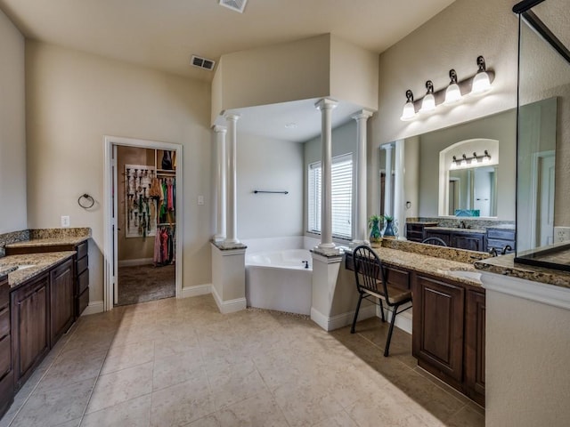 bathroom featuring decorative columns, visible vents, a bath, and vanity