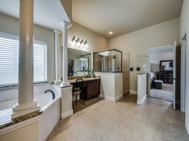 full bathroom featuring baseboards, a garden tub, vanity, ornate columns, and a walk in shower