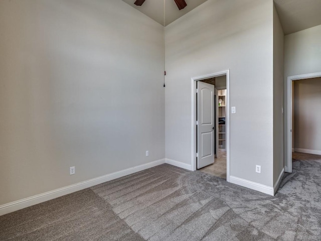 unfurnished bedroom with ceiling fan, light colored carpet, and high vaulted ceiling