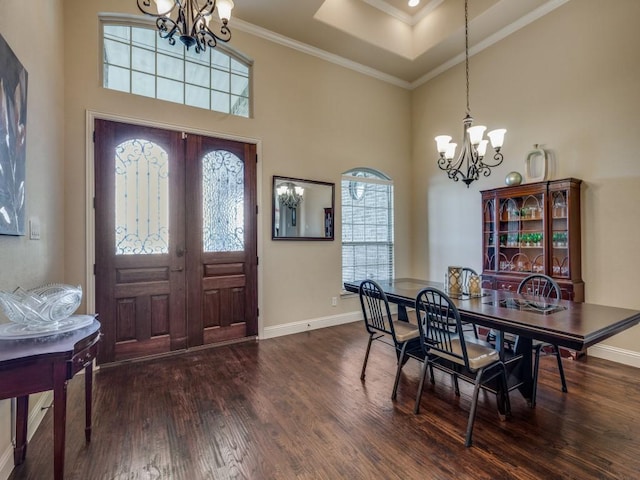 dining space with ornamental molding, dark hardwood / wood-style floors, a notable chandelier, and french doors