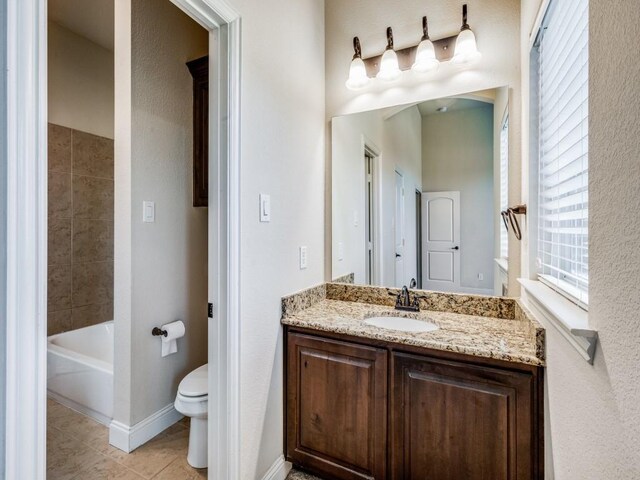 full bathroom with tiled shower / bath combo, vanity, tile patterned floors, and toilet