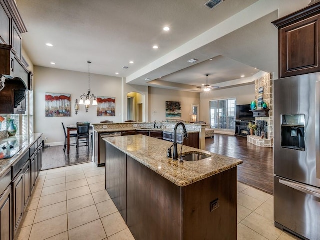 kitchen featuring a large island, light tile patterned floors, hanging light fixtures, appliances with stainless steel finishes, and a sink