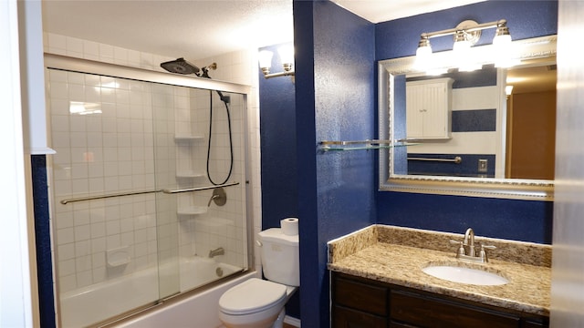 full bathroom with vanity, bath / shower combo with glass door, and toilet