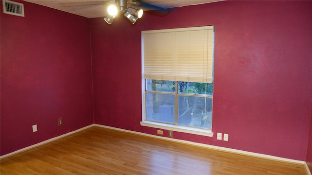 empty room with hardwood / wood-style floors and ceiling fan