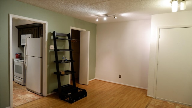 interior space featuring a textured ceiling and light hardwood / wood-style flooring