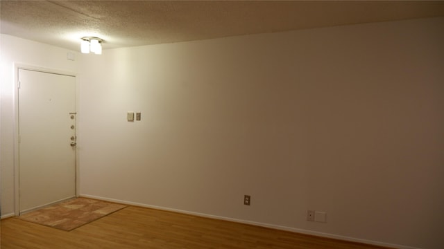 unfurnished room featuring a textured ceiling and hardwood / wood-style flooring