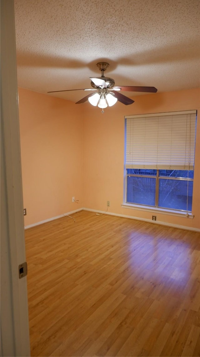 unfurnished room with wood-type flooring, a textured ceiling, and ceiling fan