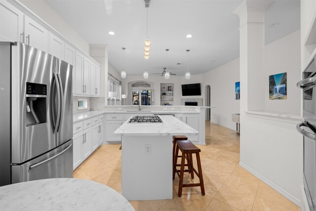 living room with built in features, ceiling fan, light tile patterned floors, and a fireplace