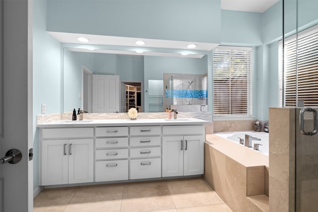 bathroom featuring plus walk in shower, vanity, and tile patterned flooring