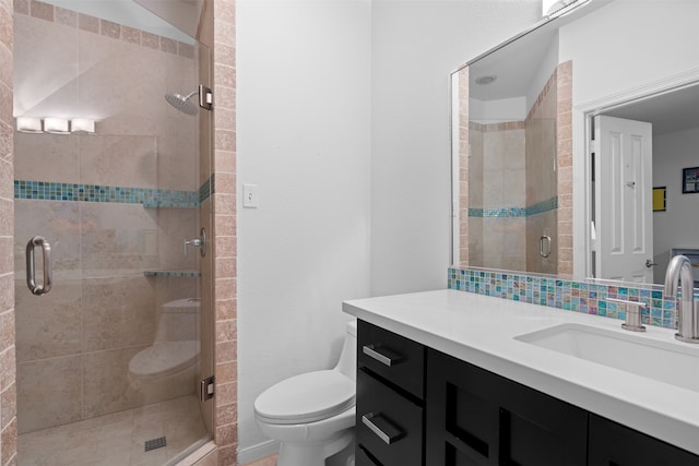 bathroom featuring vanity, toilet, walk in shower, and decorative backsplash