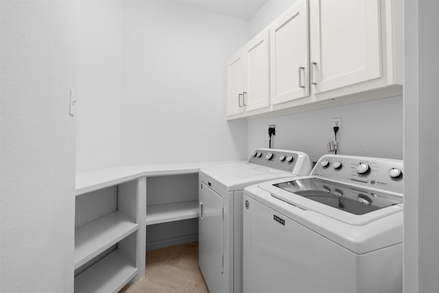 laundry room featuring light tile patterned floors, cabinets, and washer and dryer