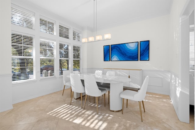 dining space featuring crown molding and light tile patterned flooring