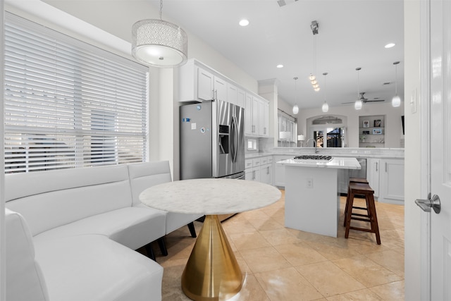 kitchen with pendant lighting, white cabinetry, kitchen peninsula, and a kitchen island