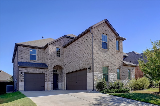 view of front of property with central AC unit and a garage