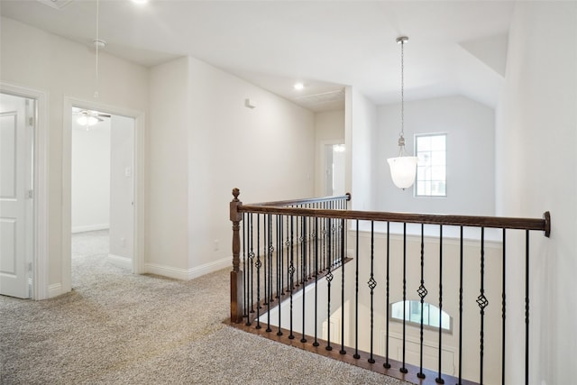 corridor with vaulted ceiling and carpet