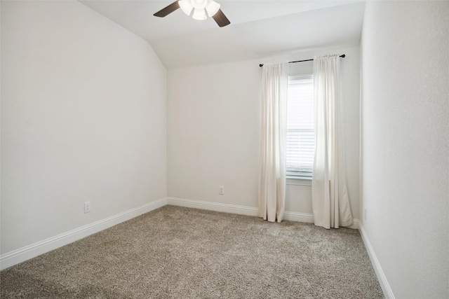 empty room featuring ceiling fan, vaulted ceiling, and light carpet